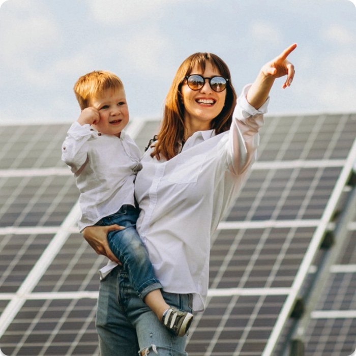 Family standing in front of solar panels